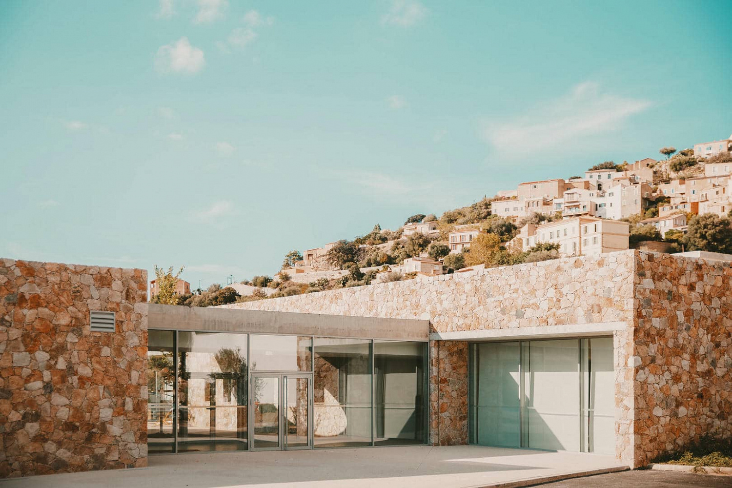 Amelia Tavella Architectes завершает строительство школы, облицованной гранитом, на скалистом побережье Корсики